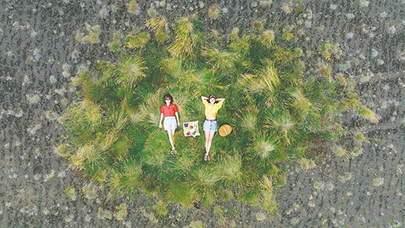 Julia Brenner e Björk Brynjarsdóttir descansam em um oásis verde dentro de uma paisagem erodida no Condado de Rangárvallasýsla, revivida em 2022 por meio do seu sistema de geração de fertilizantes a partir de resíduos. (Foto cortesia de Karim Iliya)
