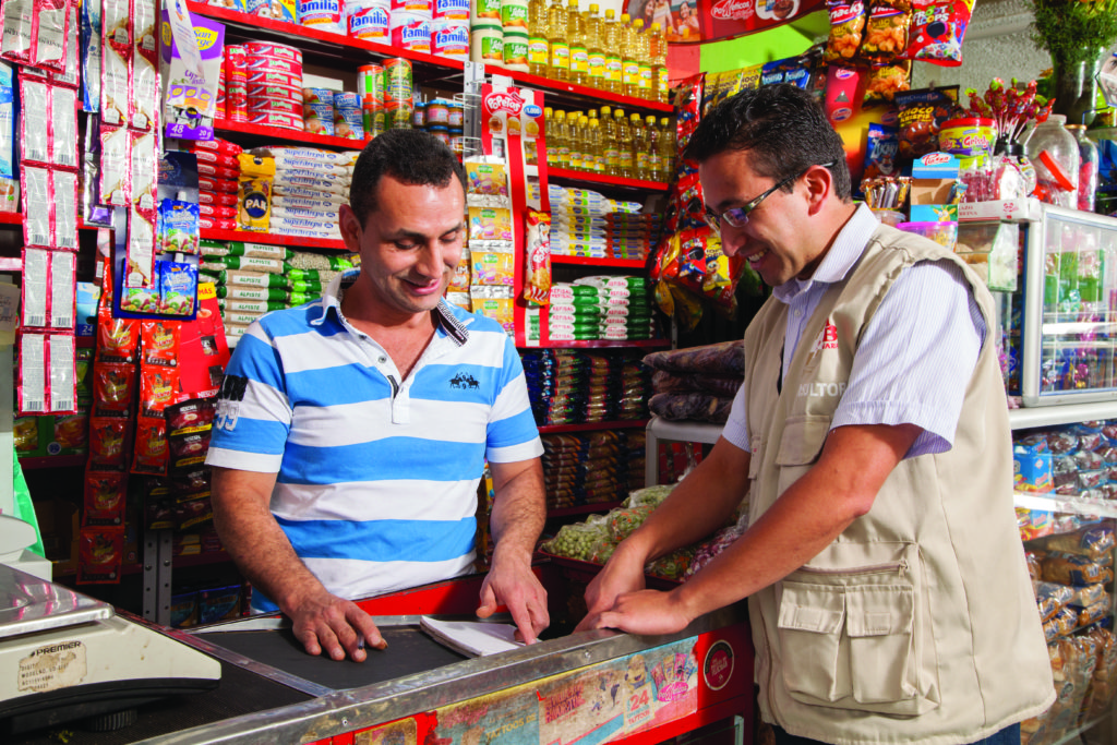 Comerciante de uma MPME (à esquerda) em Bogotá, Colômbia, recebe orientação de um consultor da Fundes como parte do projeto 4e, realizado em parceria com a SABMiller.