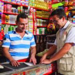 Comerciante (à esquerda) em Bogotá, Colômbia, recebe orientação de um consultor da Fundes como parte do projeto 4e, realizado em parceria com a SABMiller. Foto: Divulgação Fundes