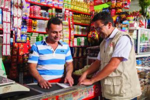 Comerciante de uma MPME (à esquerda) em Bogotá, Colômbia, recebe orientação de um consultor da Fundes como parte do projeto 4e, realizado em parceria com a SABMiller.