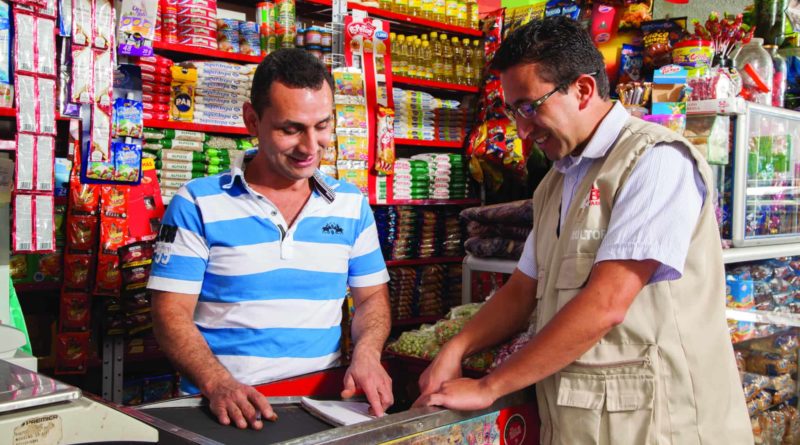 Comerciante de uma MPME (à esquerda) em Bogotá, Colômbia, recebe orientação de um consultor da Fundes como parte do projeto 4e, realizado em parceria com a SABMiller.