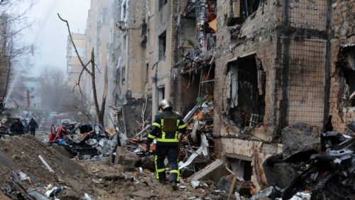 Um bombeiro em frente a um prédio destruído no centro de Kiev em 2 de janeiro de 2024, no contexto da invasão russa na Ucrânia