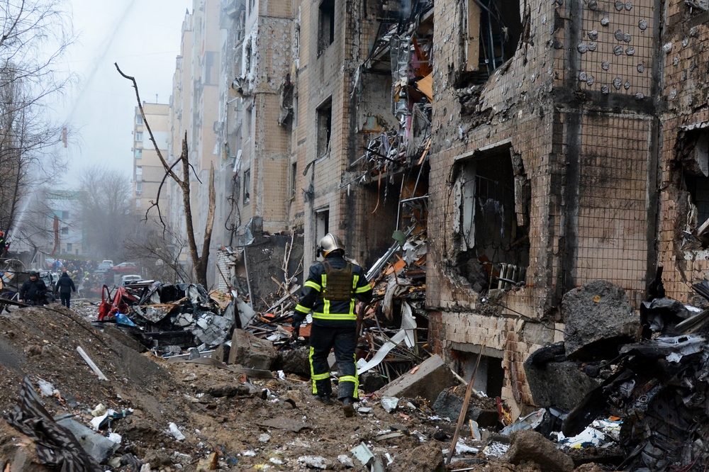 Um bombeiro em frente a um prédio destruído no centro de Kiev em 2 de janeiro de 2024, no contexto da invasão russa na Ucrânia