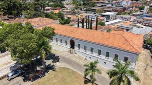 vista aérea do Museu Vassouras, grande prédio branco em estilo colonial, com árvores à frente e a cidade de Vassouras ao fundo