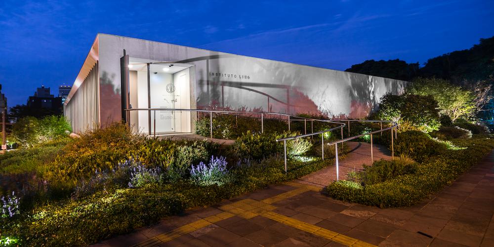 Vista noturna do prédio sede do Instituto Ling, prédio cinza em formato retangular com um jardim à frente
