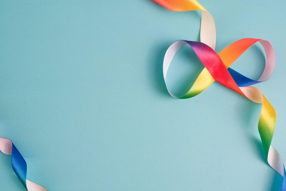 Fita de cetim infinito em forma de arco-íris no fundo azul claro