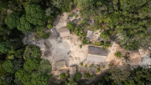Vista aérea de casas tradicionais indígenas nas proximidades de Manaus (AM). A foto mostra o telhado de oito casas de diferentes tamanhos em um clarão da floresta