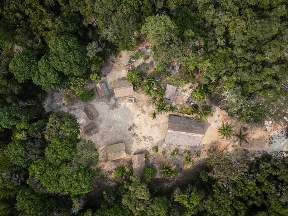 Vista aérea de casas tradicionais indígenas nas proximidades de Manaus (AM). A foto mostra o telhado de oito casas de diferentes tamanhos em um clarão da floresta